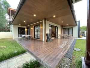 una gran terraza con sillas y mesas en una casa en Villa La Vimala en Gadok 1