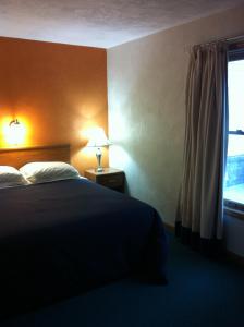Habitación de hotel con cama y ventana en East Street Inn & Suites, en Tipton