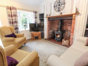 a living room with a fireplace and a tv at Riverlea in Rhyl