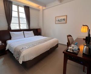 a bedroom with a bed and a desk and a window at 饒宗頤文化館 - 翠雅山房 in Hong Kong