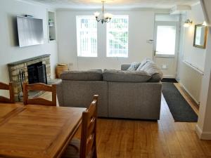 a living room with a couch and a table at Ty Bryn Cottage in Kenfig Hill