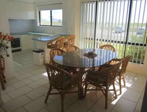 a dining room with a glass table and chairs at Hi Surf Unit 2, 92 Head Street, Forster in Forster