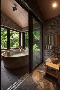 a large bath tub in a room with windows at 八海 木花館 in Oshino