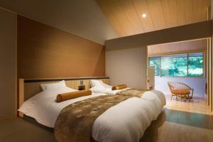 a large bedroom with two beds and a window at 八海 木花館 in Oshino