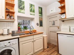 uma cozinha com um lavatório e uma máquina de lavar louça em Woodman Cottage em Skipton