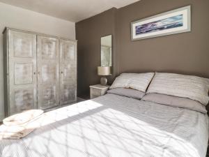 um quarto com uma cama branca e um espelho em Woodman Cottage em Skipton