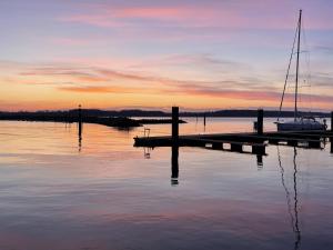 a sailboat is docked at a dock at sunset at Floating Home Nr 1 in Laboe