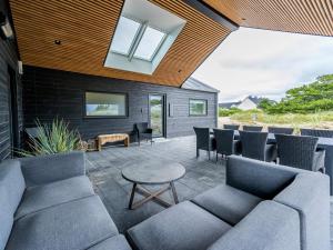 un patio con sofá, sillas y mesa en Holiday home Henne CXXVI en Henne Strand