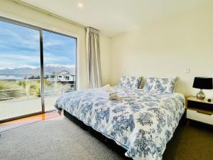 a bedroom with a bed and a large window at Antair Lakeview Lodge in Lake Tekapo