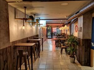 a restaurant with tables and chairs in a room at Gran piso en el centro de Alcalá in Alcalá de Henares