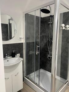 ein Bad mit einer Dusche und einem Waschbecken in der Unterkunft AZZA Aparthotel in Bukarest