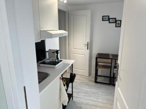 a small white kitchen with a sink and a counter at AZZA Residence in Bucharest