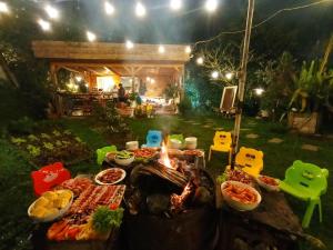 a table full of food next to a fire at Nấp ở TEEPEE homestay in Da Lat