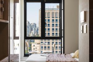 a bedroom with a window with a view of a city at Urbanstay Seomyeon in Busan