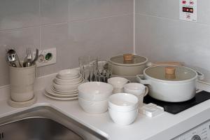 un bancone della cucina con pentole, padelle e piatti bianchi di Urbanstay Seomyeon a Busan
