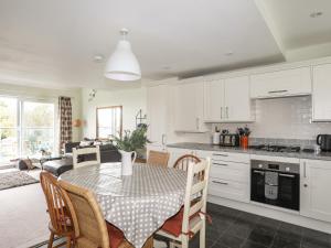 a kitchen and dining room with a table and chairs at Machlud Ynys in Y Felinheli