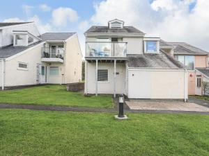 a large white house with a grass yard at Machlud Ynys in Y Felinheli