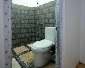 uma casa de banho com um WC numa parede de tijolos em RedDoorz Syariah near Universitas Bengkulu em Bengkulu