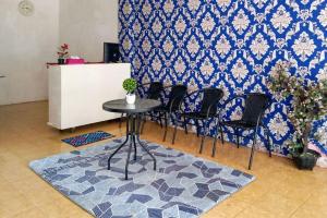 ブンクルにあるRedDoorz Syariah near Universitas Bengkuluの青い壁の客室で、テーブルと椅子が備わります。