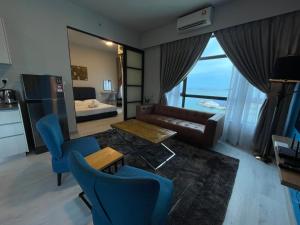 een woonkamer met een bank en een tafel bij SEAVIEW LUXURY CONDO HOMESTAY 2Bed 2bath Jesselton Quay by R2 Residence in Kota Kinabalu