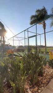 a batting cage with palm trees in the background at Il Campanario - Vista Para a Piscina in Florianópolis