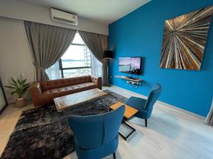 a living room with blue walls and a couch and chairs at SEAVIEW LUXURY CONDO HOMESTAY 2Bed 2bath Jesselton Quay by R2 Residence in Kota Kinabalu