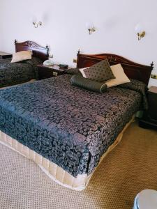 a bedroom with a bed with a blue comforter at Australian Heritage Motor Inn in Dubbo +26 photos
