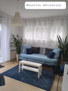 - un salon avec un canapé bleu et une table dans l'établissement La Bernaudine, à Annonay