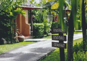 a street sign in front of a house at Ban Sainai Resort- SHA Extra Plus Aonang's Green Resort in Ao Nang Beach