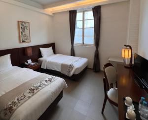 a hotel room with two beds and a television at 饒宗頤文化館 - 翠雅山房 in Hong Kong