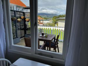 a window with a table with a cup of coffee on a balcony at Raglan Retreat on Gilmour in Raglan