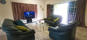 - un salon avec deux chaises et une télévision dans l'établissement PD Villa 12 Homestay, à Port Dickson