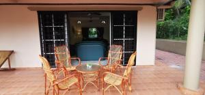 une table et des chaises assises sur une terrasse dans l'établissement PD Villa 12 Homestay, à Port Dickson