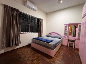 - une chambre avec un lit rose et une fenêtre dans l'établissement PD Villa 12 Homestay, à Port Dickson