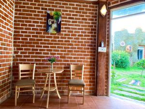 a patio with a table and chairs next to a brick wall at Hotel Cù Lao 2 in Ấp Bồ Lớn +76 photos
