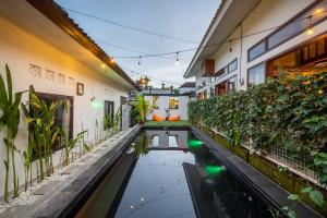 een binnenplaats met een vijver in een huis met planten bij Old Style Surf Apartment with Private Kitchen and Shared Pool Canggu in Canggu