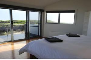 um quarto com uma cama com duas toalhas em Wave Retreat, King Island em Loorana