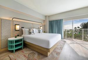 a bedroom with a large bed and a balcony at Crowne Plaza Resort Saipan in Garapan
