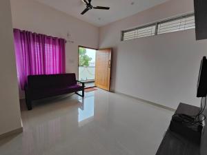 sala de estar con sofá y ventana en Lishan Apartment, en Mysore