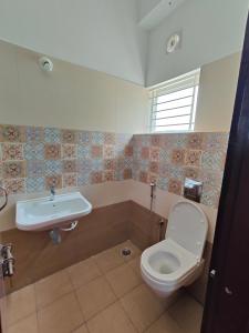 y baño con aseo y lavamanos. en Lishan Apartment, en Mysore