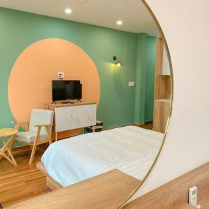 een slaapkamer met een bed en een spiegel bij POTA Hotel & Apartment in Da Nang