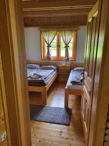 a bedroom with two beds and a window at Wooden House Ripac in Bihać