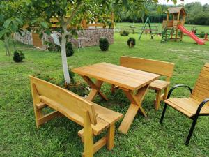 a picnic table and two chairs and a playground at Wooden House Ripac in Bihać