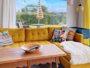 a living room with a yellow couch with a wooden coffee table at Holiday home Aabenraa LXIII in Aabenraa