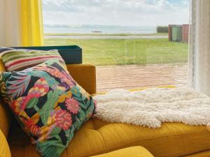a yellow couch with a pillow and a window at Holiday home Aabenraa LXIII in Aabenraa