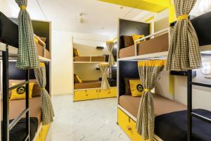 Habitación compartida con literas de color amarillo y negro en The Hosteller Agra, en Agra