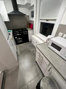 a kitchen with a stove and a microwave at Alfaomega in London