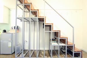 escalera de metal en una habitación con nevera en LikeU Guest house, en Seúl