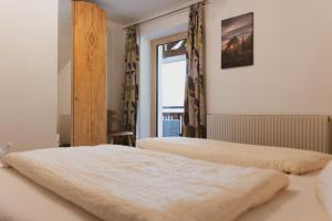 two beds in a room with a window at Haus Möslehof in Kauns