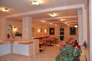 a restaurant with tables and chairs in a room at Pension zum Schreiner in Hermagor